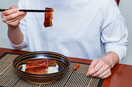 Person eating eel on rice at home