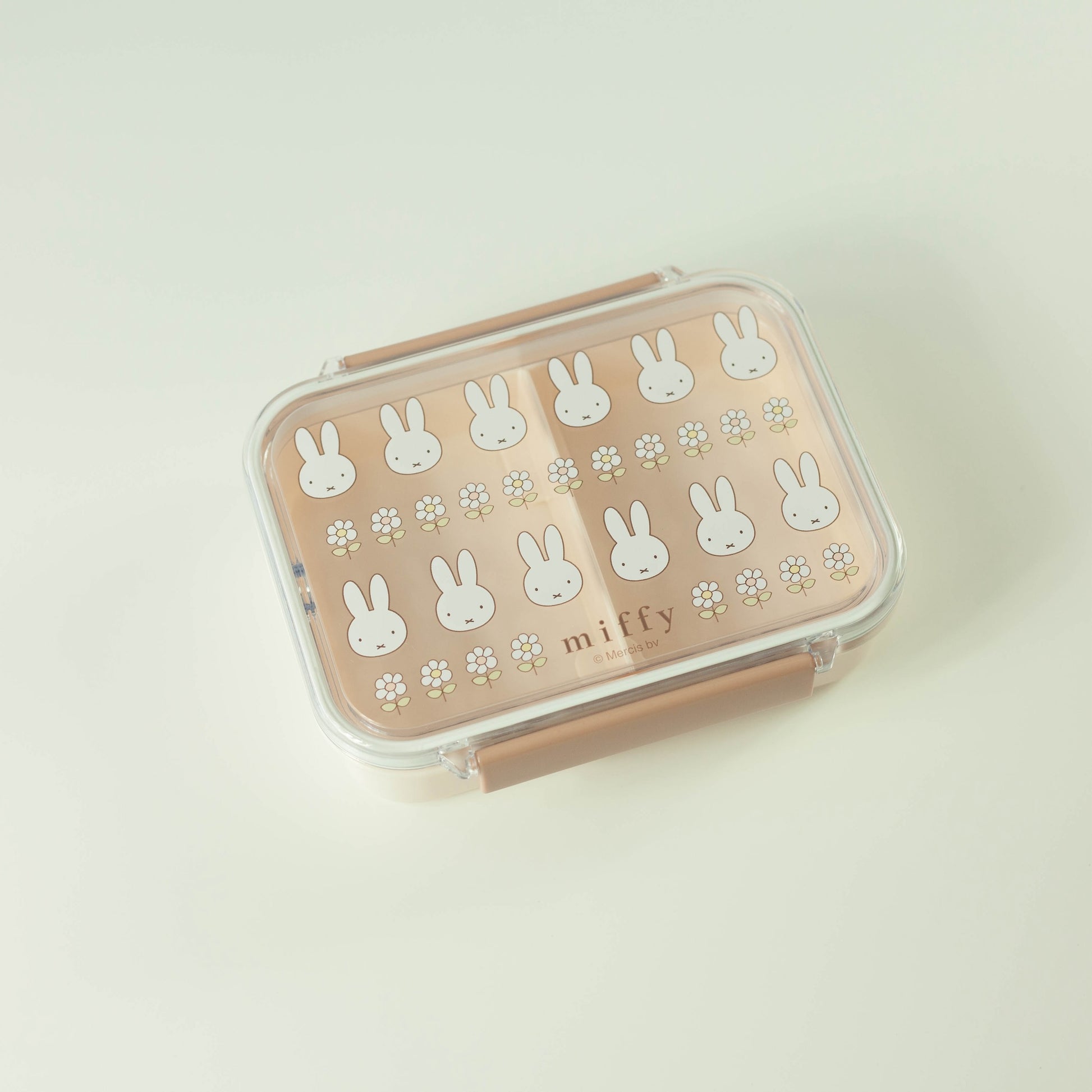 Pink lunch box with white bunny patterns on a light beige background