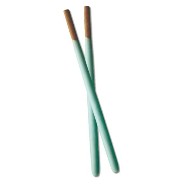 Two green Pocky with brown tips on a white background
