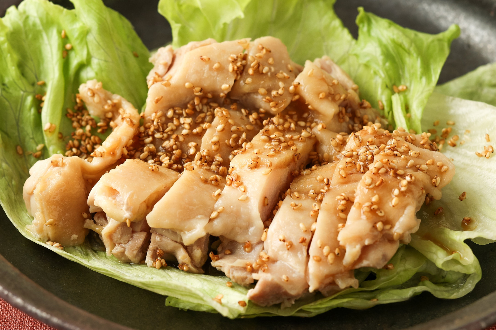 Furikake sprinkled on top of sliced chicken sitting in a place on a bed of lettuce