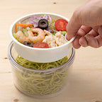 Gel-Cool Round Salad Case Oyster Gray filled with food, with a hand holding the inner tray
