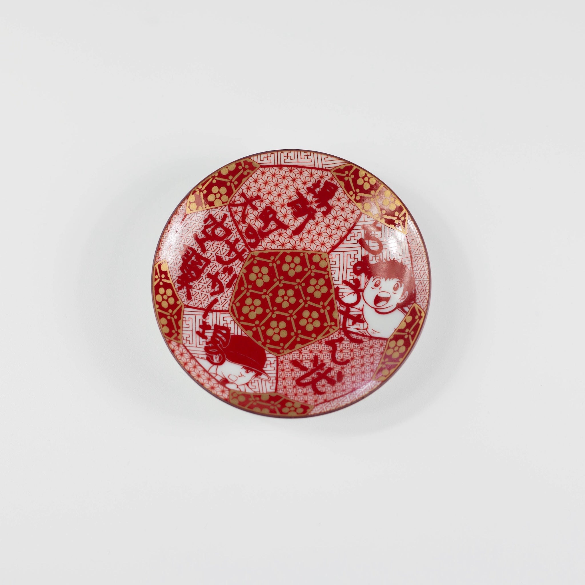 Decorative plate with red and gold pattern and cartoon characters on a white background