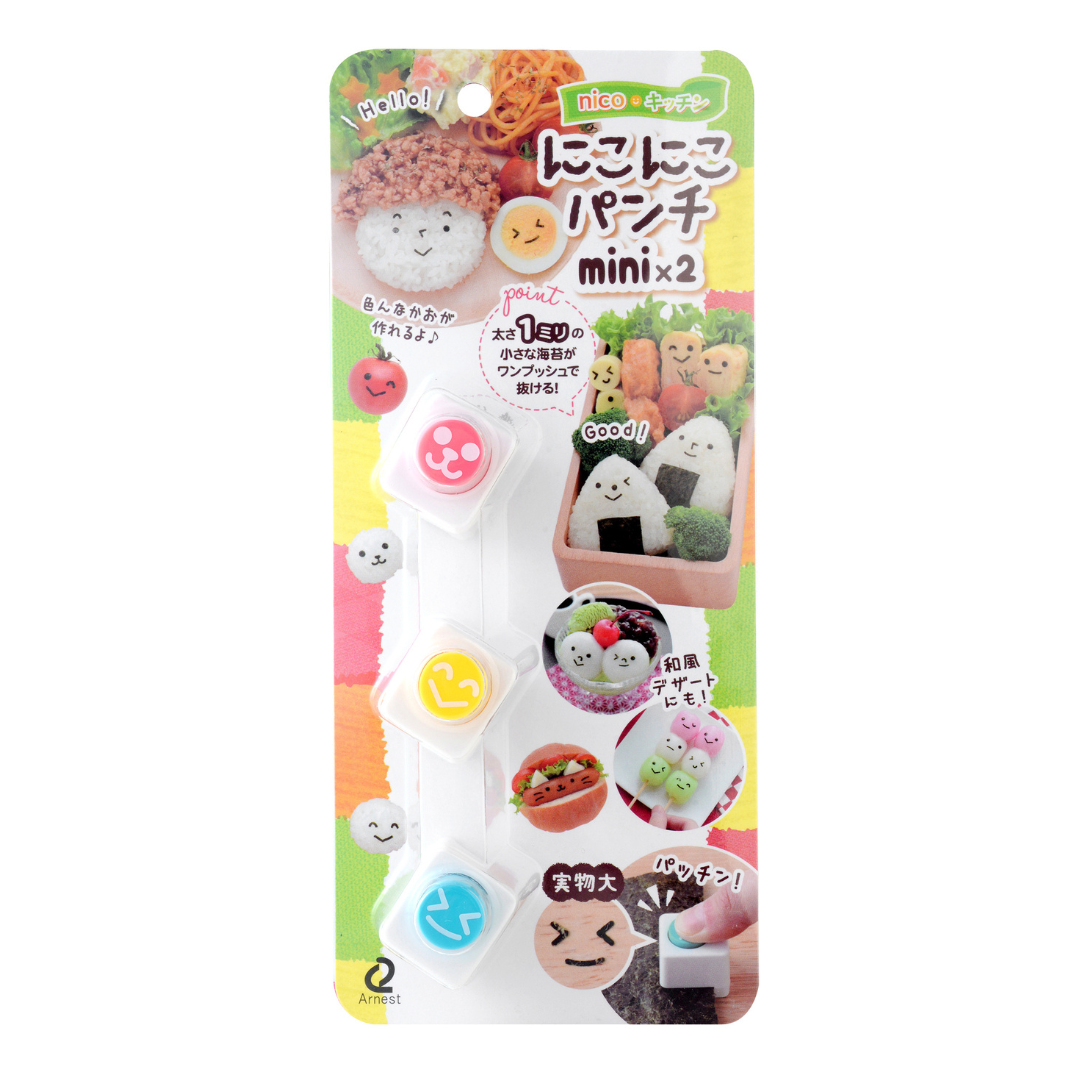 Arnest Nico Nico Nori Puncher Mini x2 retail packaging – three white square nori punches with pink, yellow, and teal emoji-face buttons on a colorful Japanese card showing example uses on onigiri, vegetables, and desserts, on white background
