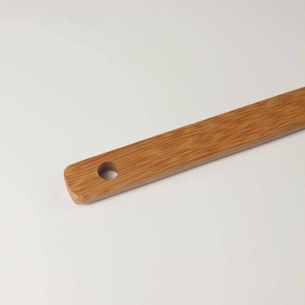 Close-up of the bamboo spatula handle showing its round hanging hole and natural bamboo grain
